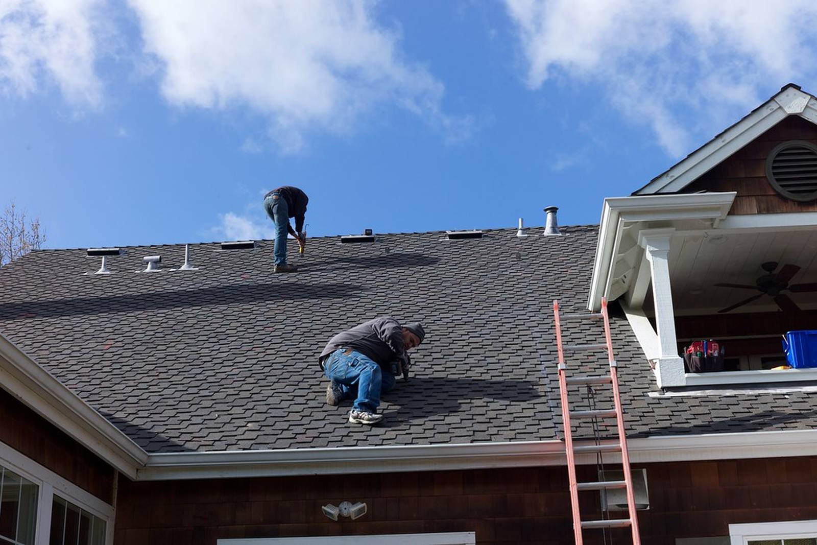 Roofer during roofing services inspecting a tile roof in the Los Angeles area